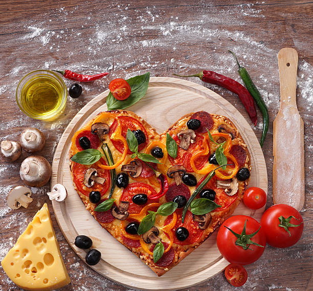 istock Heart shaped pizza served on wooden table, closeup. 509633704