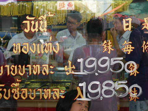 Bangkok, Thailand - February 9, 2016: External view of gold shop in China Town of Bangkok during the Chinese New Year. People are inside the shop. Gold prices are on the shopâs window.