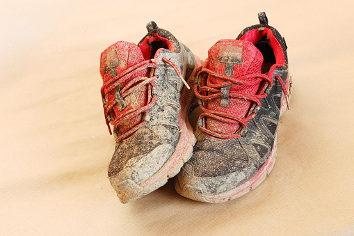 Old muddy running shoes close up photography.