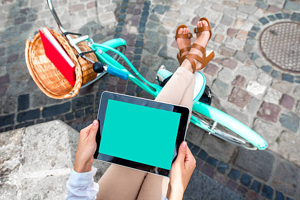 Business woman on bicycle using tablet