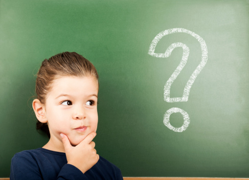 little student in front of the blackboard with question mark