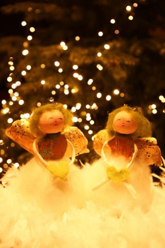 Two hand made Christmas angels holding hearts.