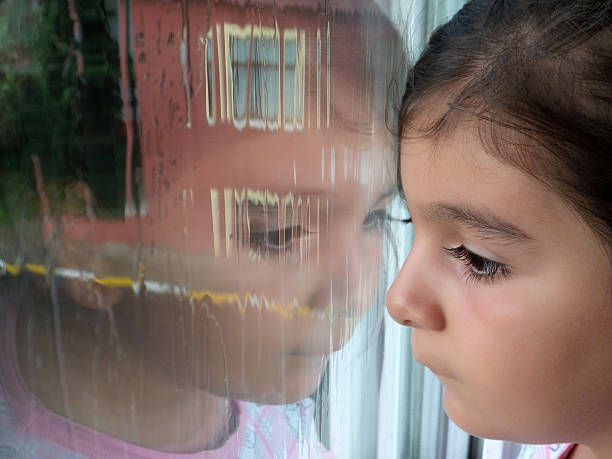 bambino guardando fuori la finestra - violence women child abuse teenager foto e immagini stock