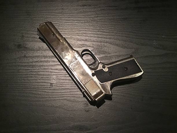 istock Chrome shiny air gun resting on table, night 509658394