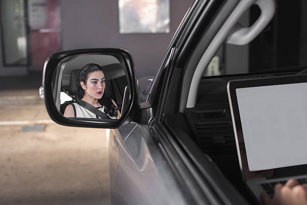 istock woman using laptop in car seeing from rearview 509659410