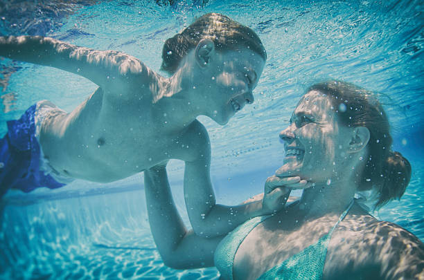 istock mother and son swimming underwater with loving play 509660082