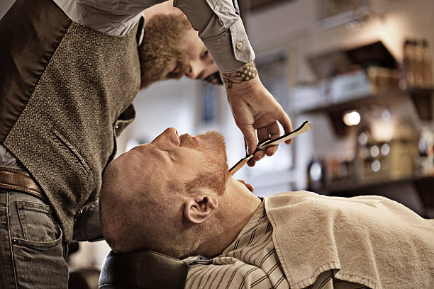 istock Stylish retro bearded barber with a bearded bald male client 509660978