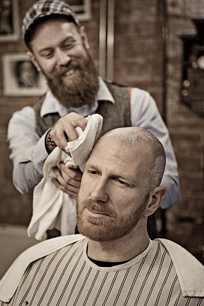 istock Stylish retro bearded barber with a bearded bald male client 509661164