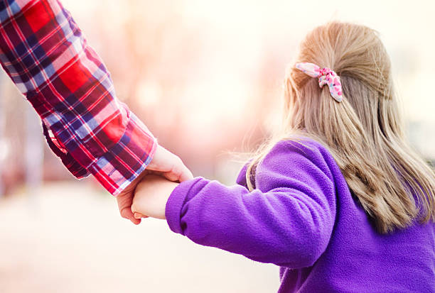istock Child walking and holding hands with her parent 509661228