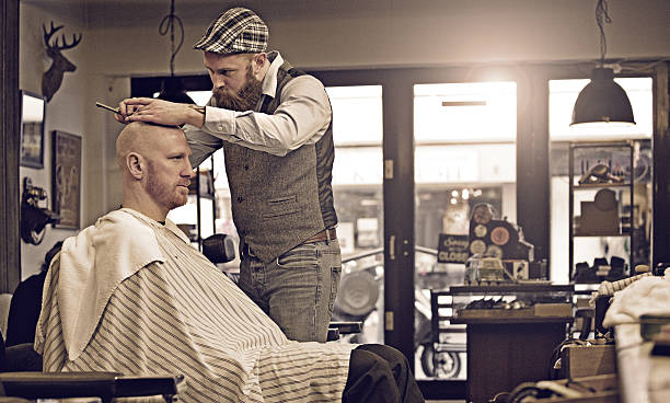Stylish retro bearded barber with a bearded bald male client