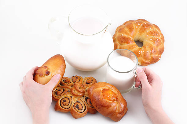 istock Female hands hold  bun and to  mug with milk 509661560