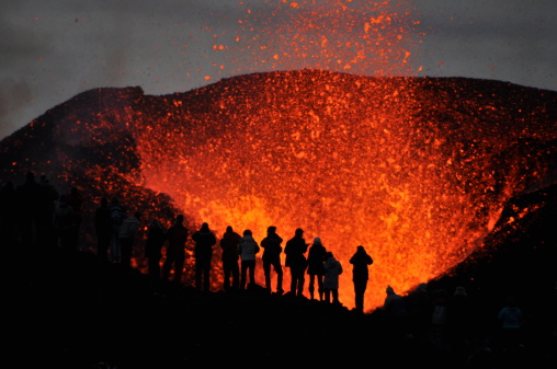The sillouette of group of adventurers witnessing the eruption of volcano Eyjafjallajökull right up close, literally meters away from the molten lava, very brave of them. Certainly a once in a life time experience!