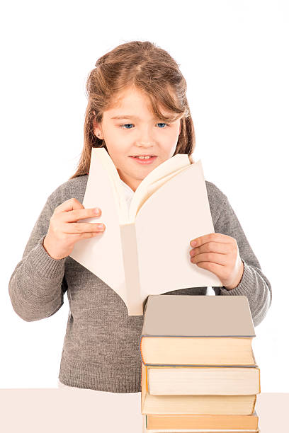 istock Little girl wearing a school uniform reading a book 509663665