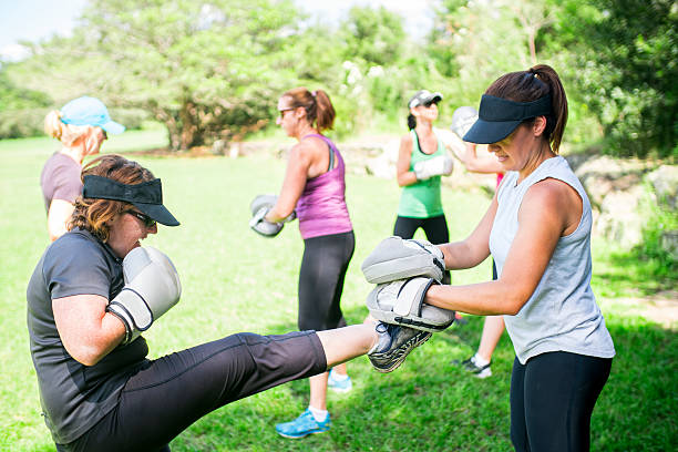 Women Cross Fitness A group of women with fitness trainer in a grassy field at an local park. Sydney, Australia weight class stock pictures, royalty-free photos & images