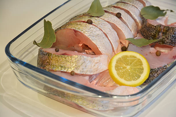 istock Sliced fish with spices in a glass tray close up 509665414