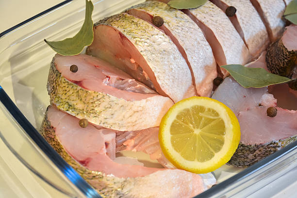 istock Appetizing slices of fish with lemon, pepper and laurel closeup 509665566