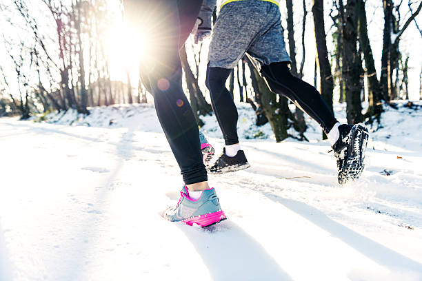 Healthy way of life Close up of legs during run on the snow. running jogging men human leg stock pictures, royalty-free photos & images