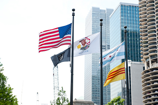 Flags waving in front of the Chicago Remembers Vietnam Memorial in Chicago, Illinois. The memorial is dedicated to veterans of Vietnam war. A part of Marina City Tower is also seen.