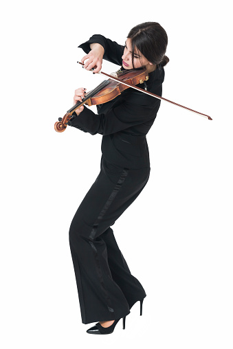 Beautiful Young Female Violinist Playing Violin. Dressed in modern stylish suit and isolated on white background.