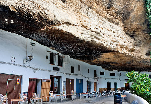Street with dwellings built into rock overhangs above Rio Trejo. Setenil de las Bodegas, Spain