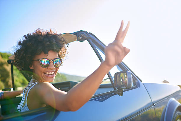 Mujer joven asomada por la ventanilla del coche - foto de stock