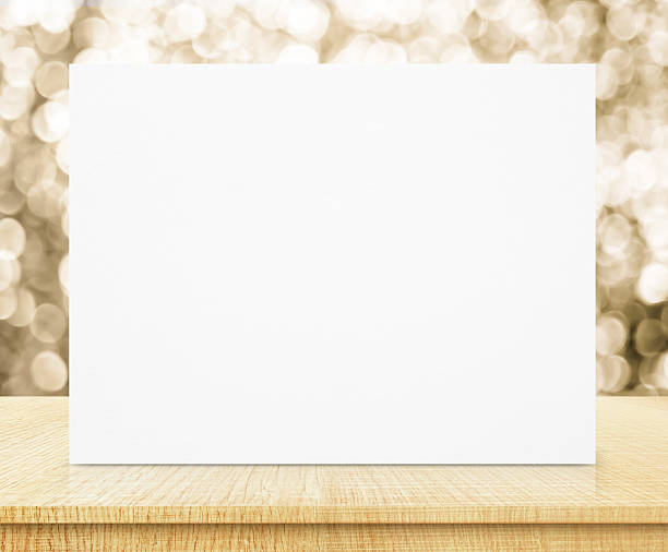 istock white poster with sparkling gold bokeh wall and wooden table 509681780