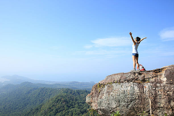 istock woman hiker enjoy the view on mountain peak cliff 509681972