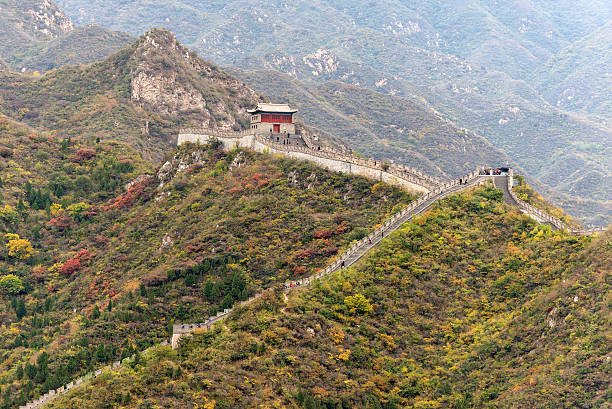 A lot of tourists (unrecognizable) visit the Great Wall of China and admiring the architectural 