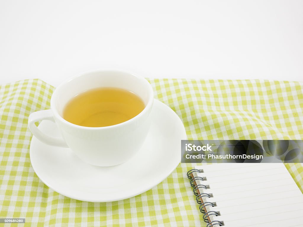 The cup of Japanese green tea and small note book The cup of Japanese green tea and small note book on green cotton fabric. Blank Stock Photo