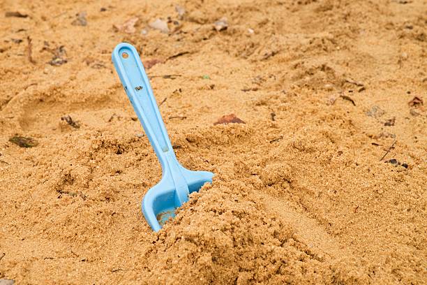 istock Blue children shovel toy on white sand, plastic toy 509684760