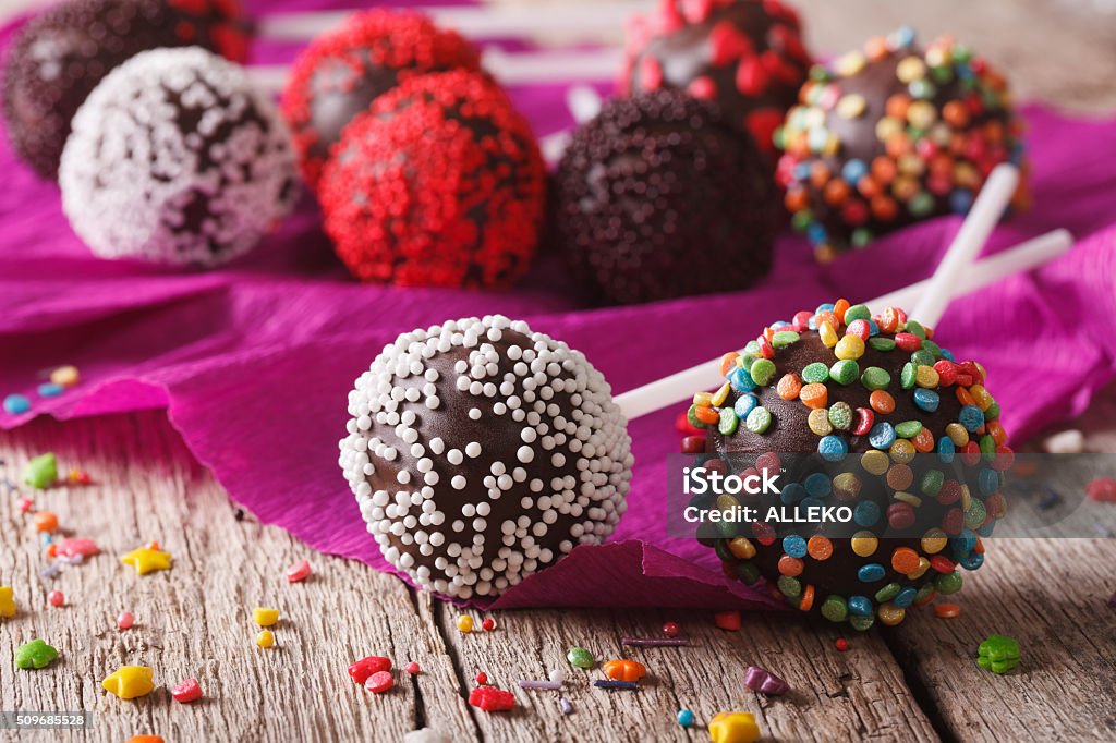Festive chocolate cake pops with candy sprinkles close-up. horiz Festive chocolate cake pops with candy sprinkles close-up on the table. horizontal Baked Stock Photo