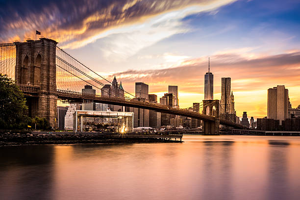 brooklyn bridge bei sonnenuntergang - new york city brooklyn bridge night stock-fotos und bilder