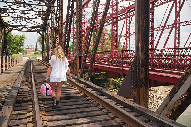 istock Blond girl walking down railroad tracks 509702159