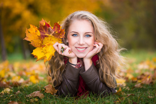 woman lying on autumn leaves, outdoor portrait