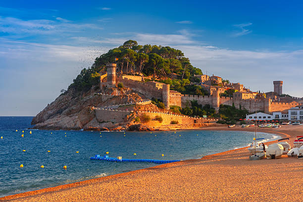 Tossa de Mar on the Costa Brava, Catalunya, Spain Fortress and fishing boats at Gran Platja beach and Badia de Tossa bay in the evening in Tossa de Mar on Costa Brava, Catalunya, Spain tossa de mar stock pictures, royalty-free photos & images