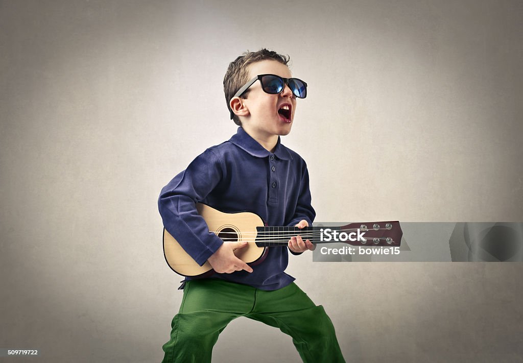 The Little Star A kid singing enthusiastically with his little guitar Child Stock Photo