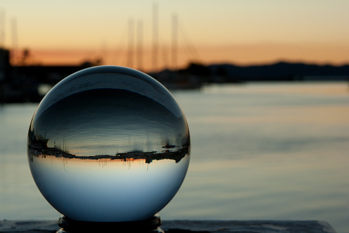 Crystal ball at sunset with boats reflected