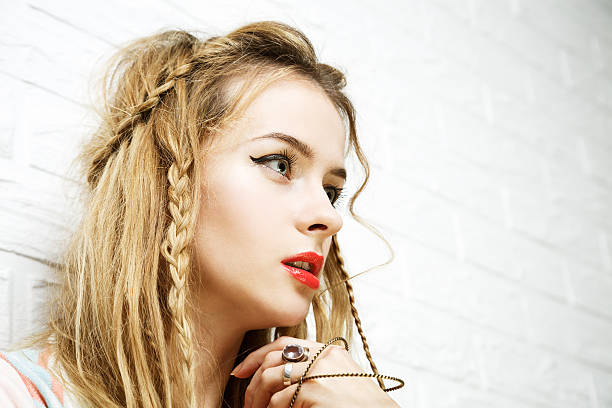 Boho Girl at White Brick Wall Background. Trendy Casual Fashion Outfit. Vintage Toned Photo with Copy Space.
