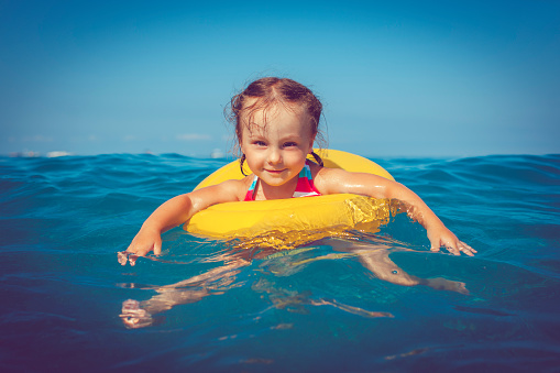 Happy little girl having fun in the sea