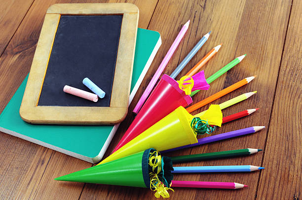 back to school chalk blackboard with back to school words. Conical bag of sweets laying aside. zuckertüte stock pictures, royalty-free photos & images