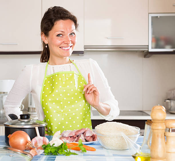 istock Woman cooking meat with rice and smiling 509725584