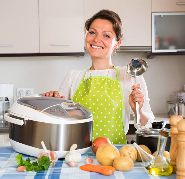 Happy  woman using slo-cooker