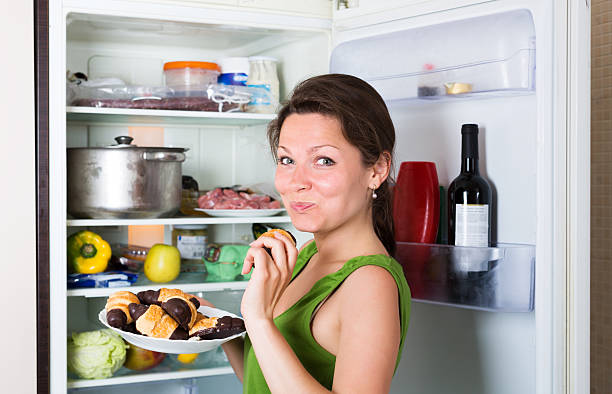 istock Girl eating cake from fridge 509726430