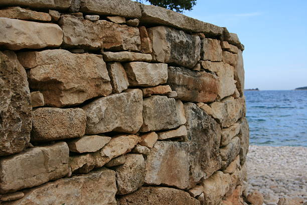 istock rustic stone wall near the sea 509728913