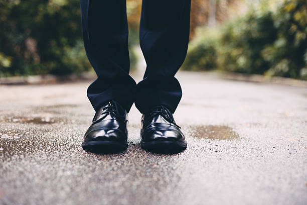 Black shoes of the groom Black shoes of the groom. Legs of groom standing at the walkway. Bridegroom at the wedding day. dress shoe stock pictures, royalty-free photos & images