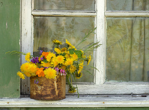 bouquet in a tin  is on the old window with peeling paint