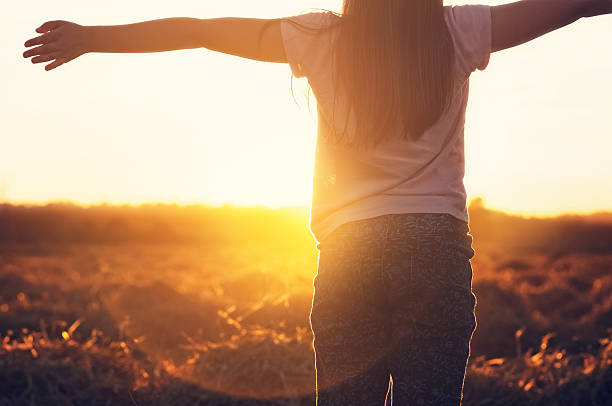 istock Young girl with outstretched arms in the sunlight 509732902