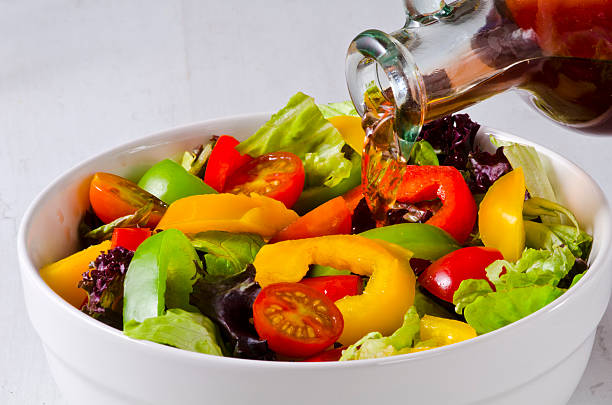 Vinegar pouring into salad bowl stock photo