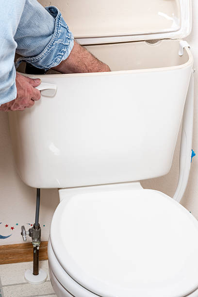 istock Plumber works on a tiolet tank 509734714