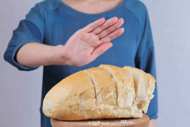 istock Woman refuses to eat white bread. Selective focus on bread 509736016